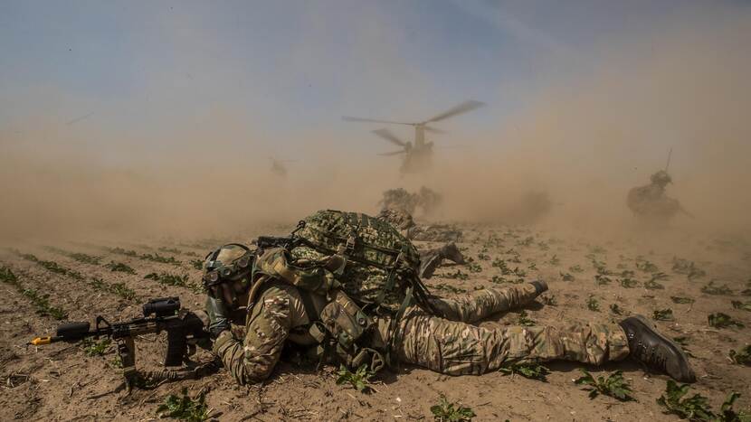 Een militair ligt op de grond.